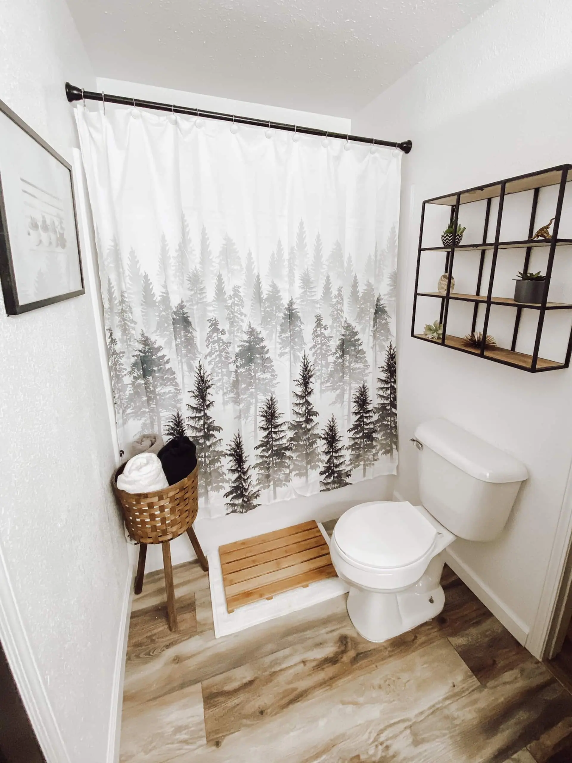 The upstairs full bathroom with a pine-forest wall hanging and warm wood wainscoting