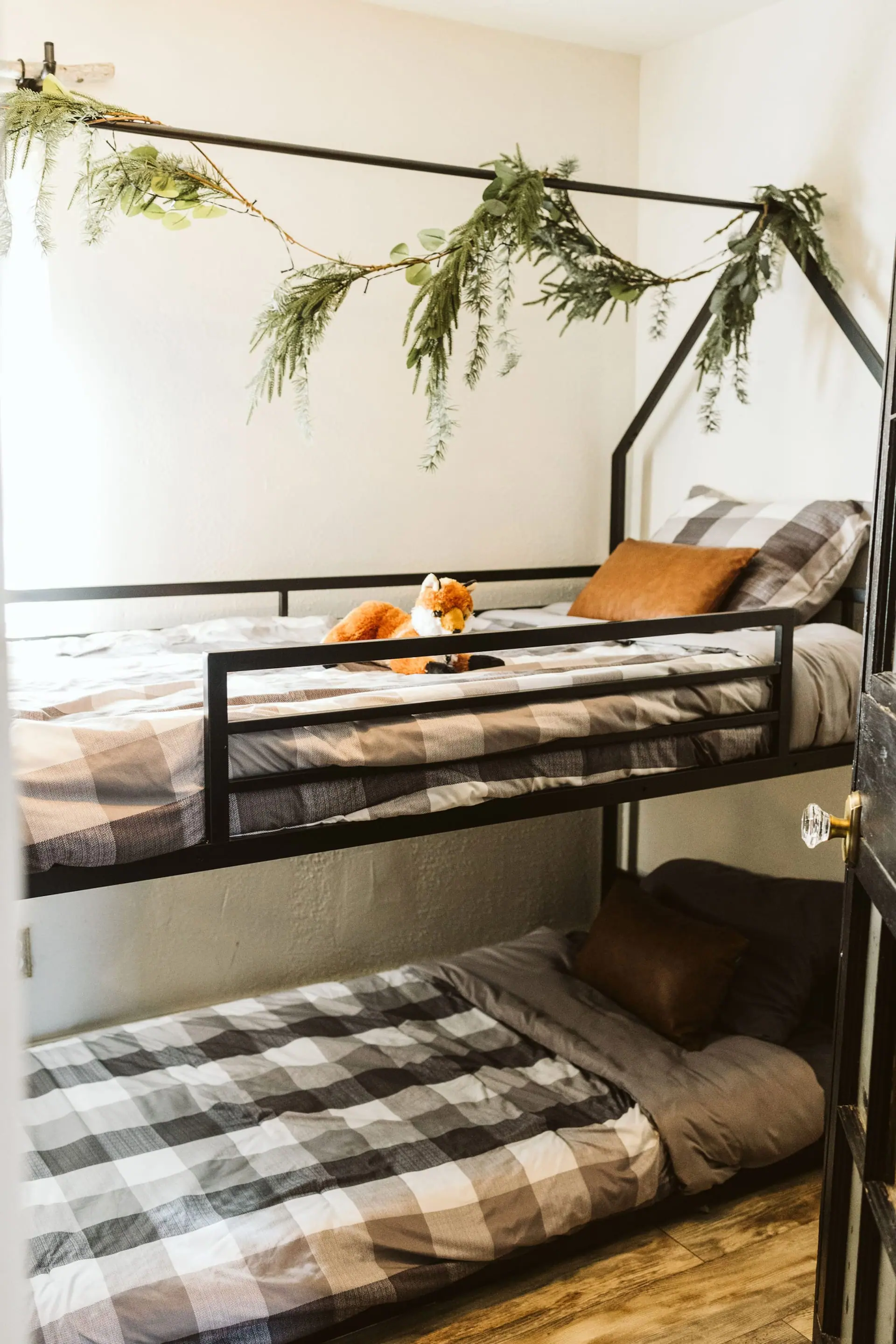 Bedroom 3 — a black metal bunk bed made up with plaid bedding