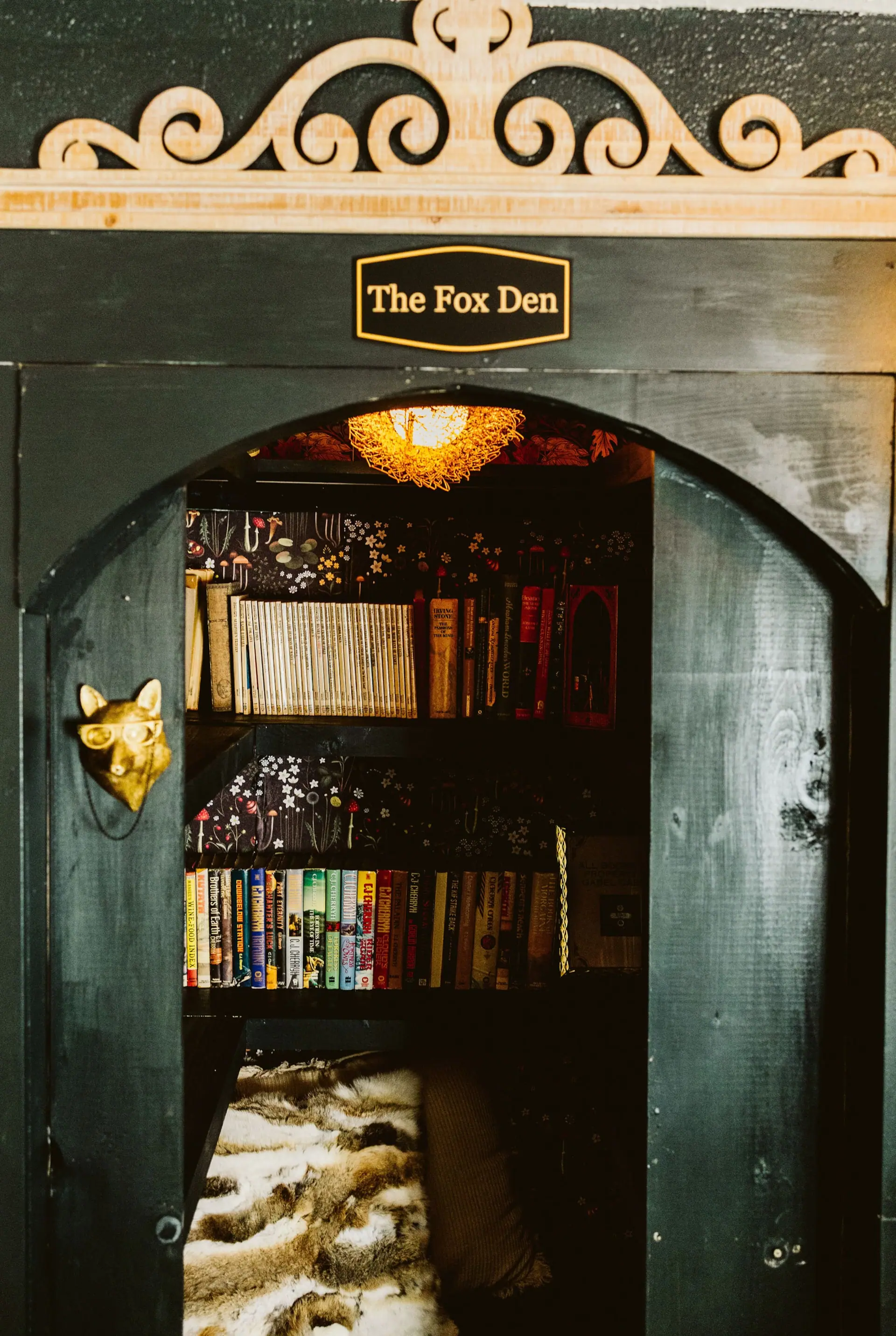 The Fox Den — an arched, deep-green reading nook lined with books