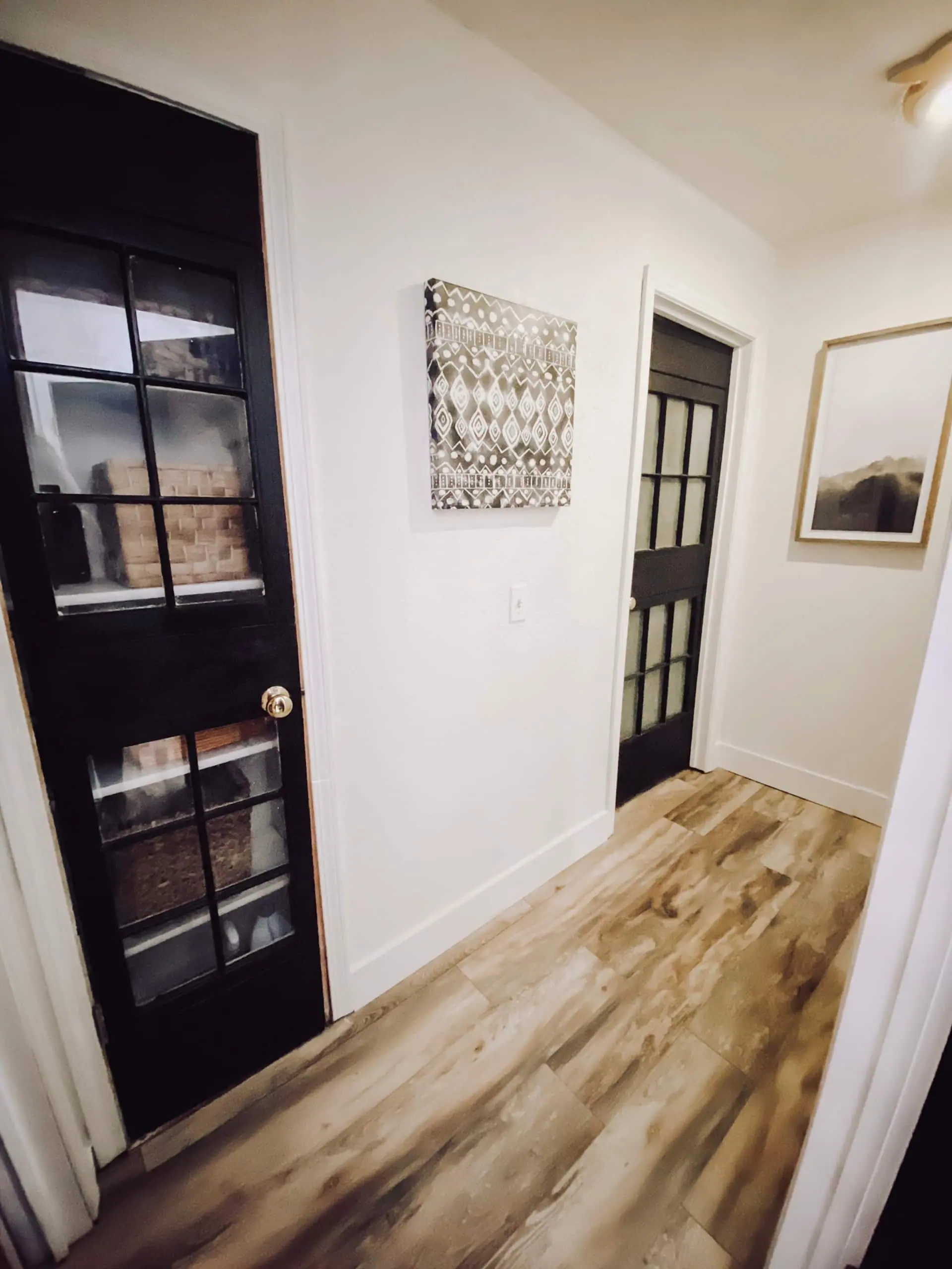 Black-paned closet doors and a book-lined shelf in the cabin’s upstairs hall