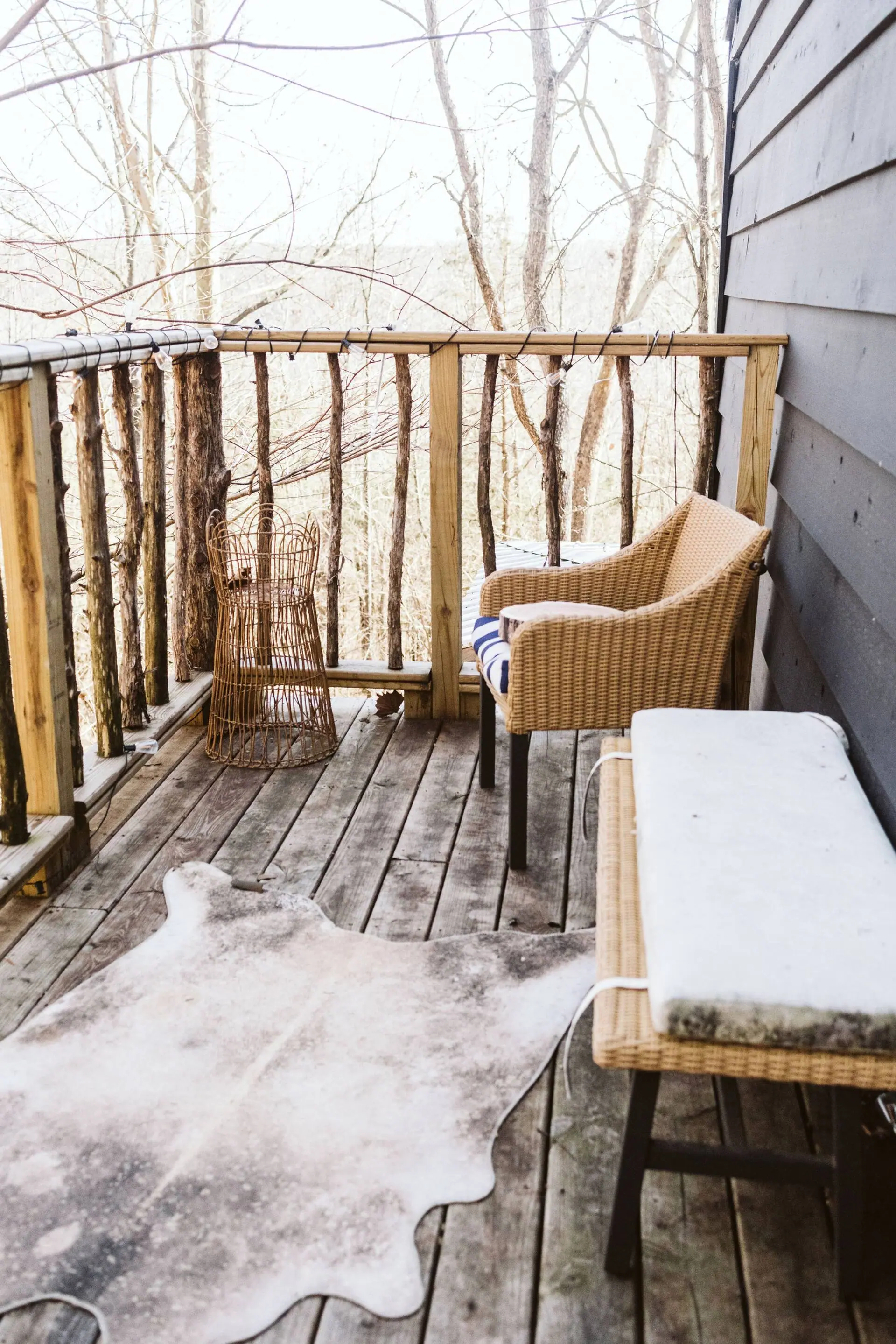 The upstairs tree-line porch with a wicker chair, level with the treetops