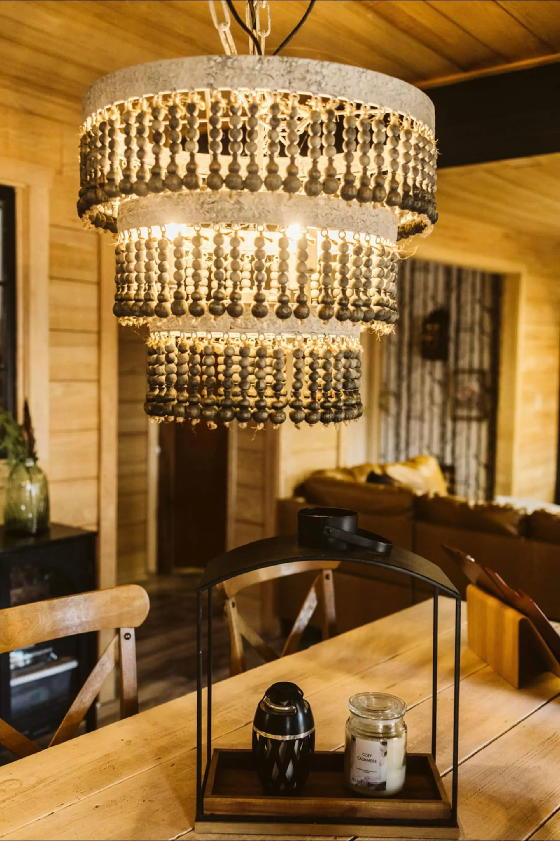 A beaded chandelier glowing above the cabin’s dining table